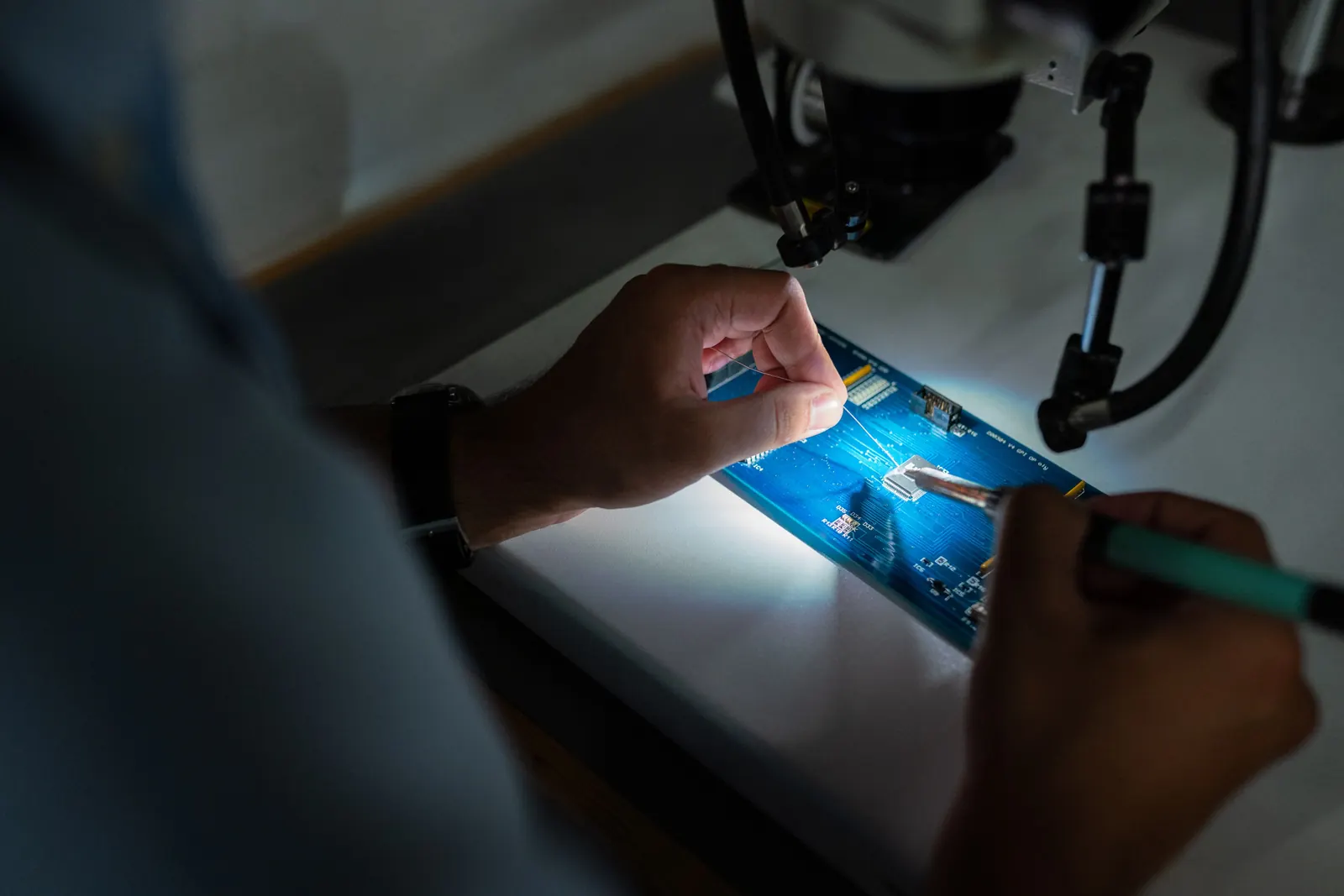 Technician soldering components onto a printed circuit board